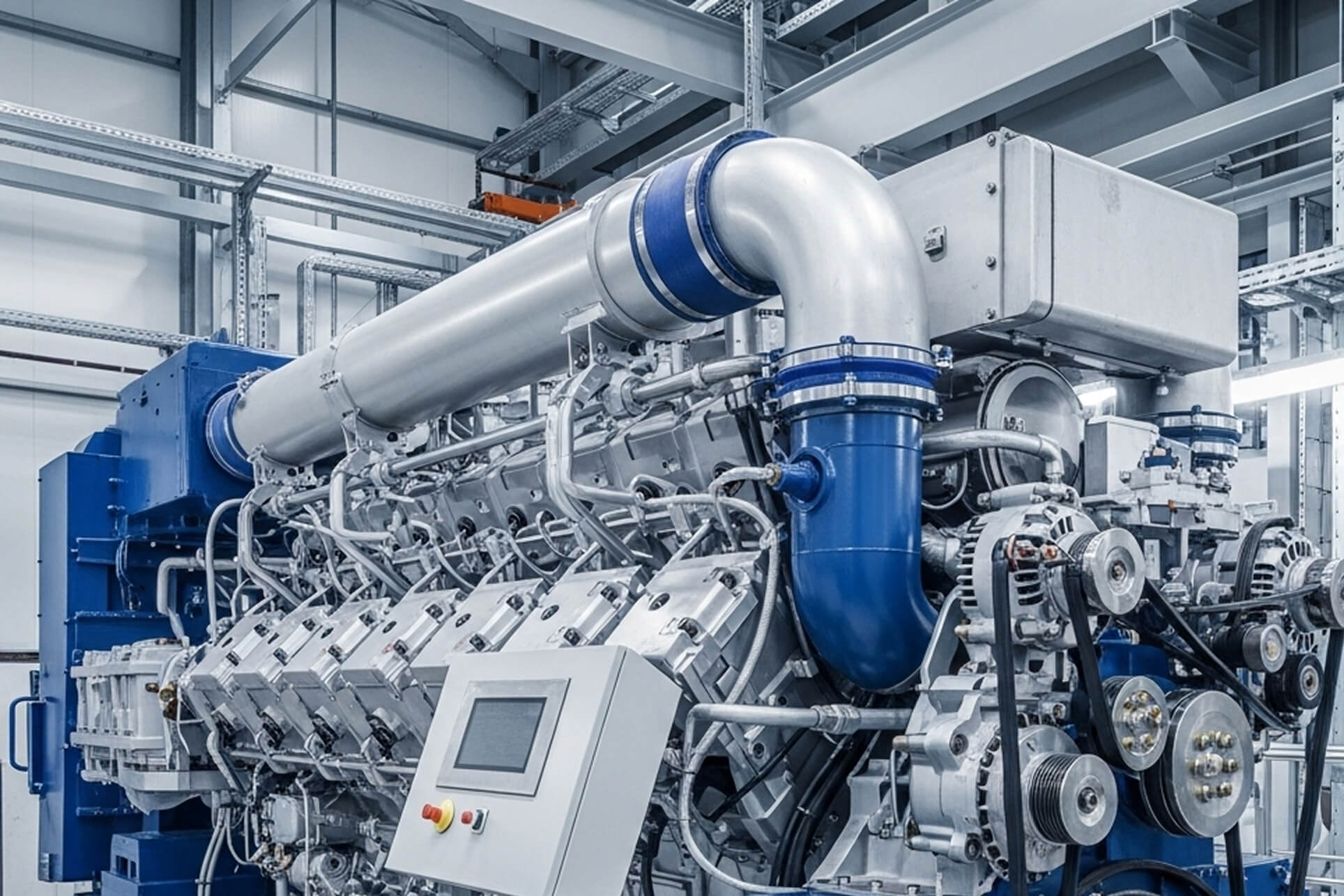 Industrial gas engine with a turbocharger and control panel in a CHP plant hall